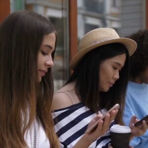 3 young beautiful girls browsing social media on their smartphones