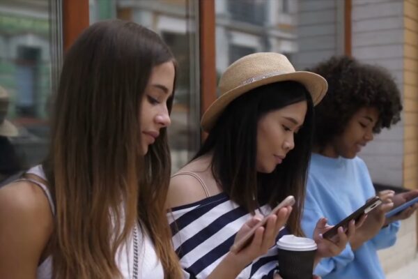 3 young beautiful girls browsing social media on their smartphones