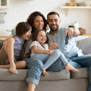 Smiling young family with little preschooler kids sit on couch