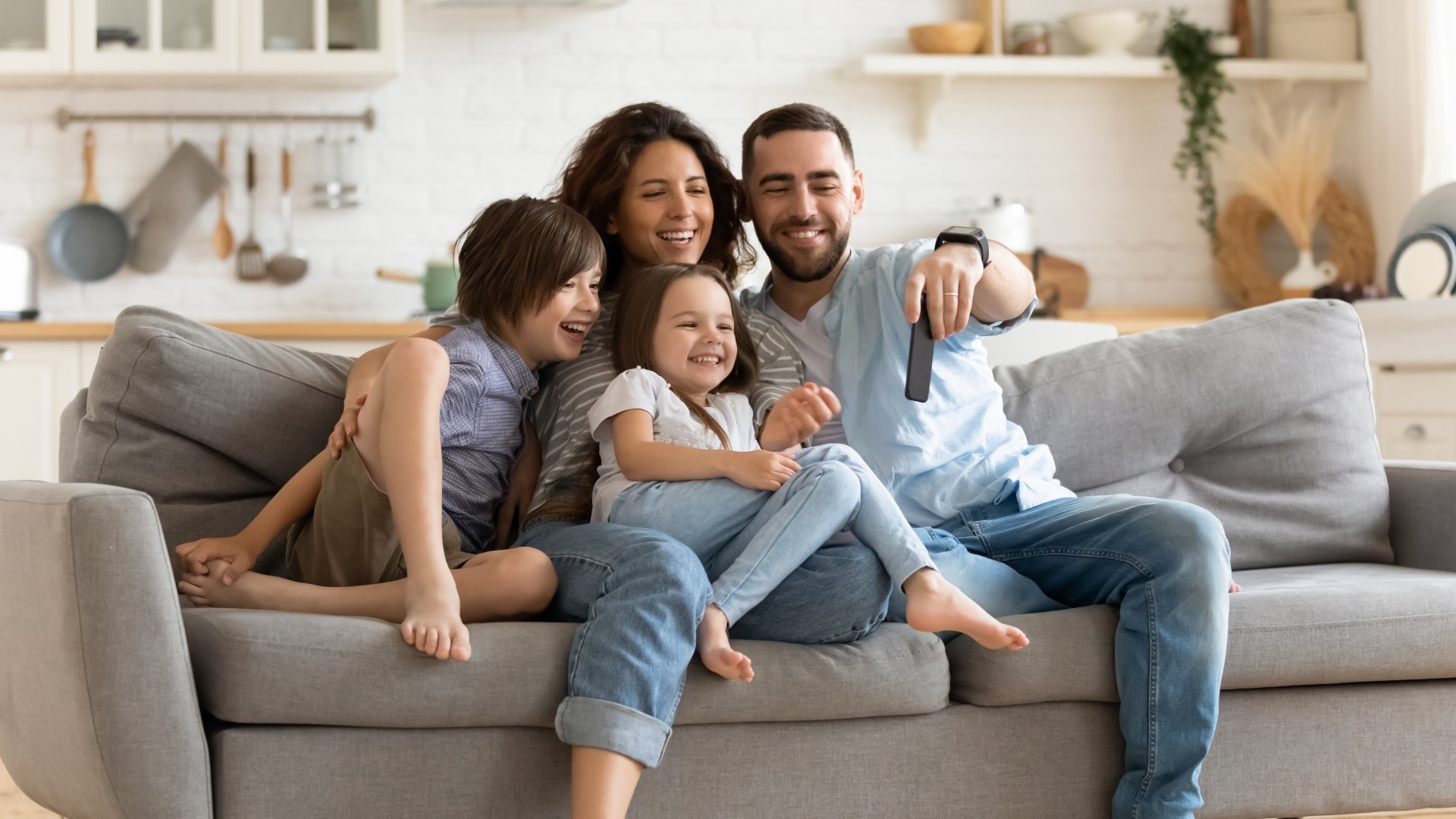 Smiling young family with little preschooler kids sit on couch